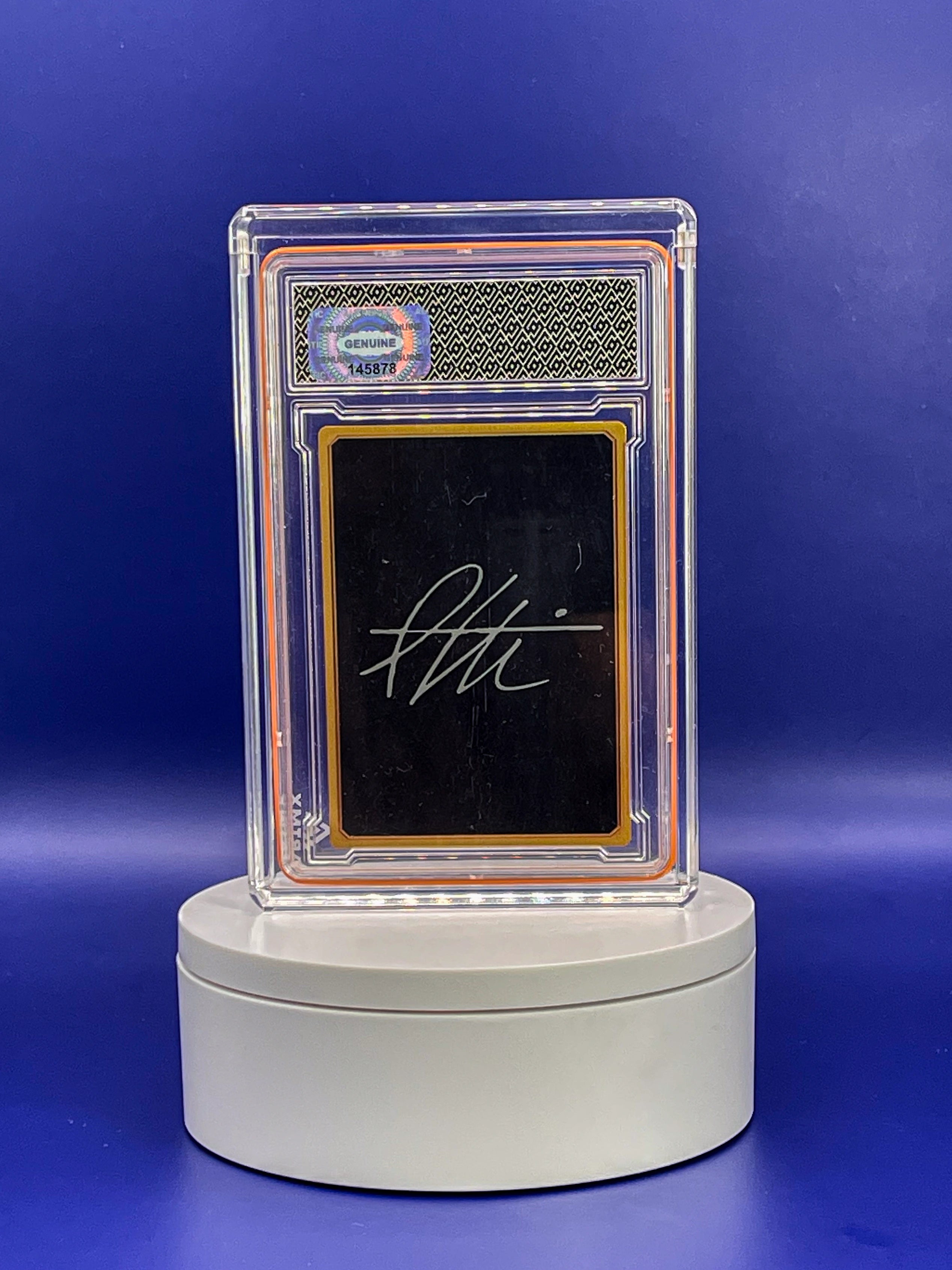 Autographed card in a protective case on a blue background