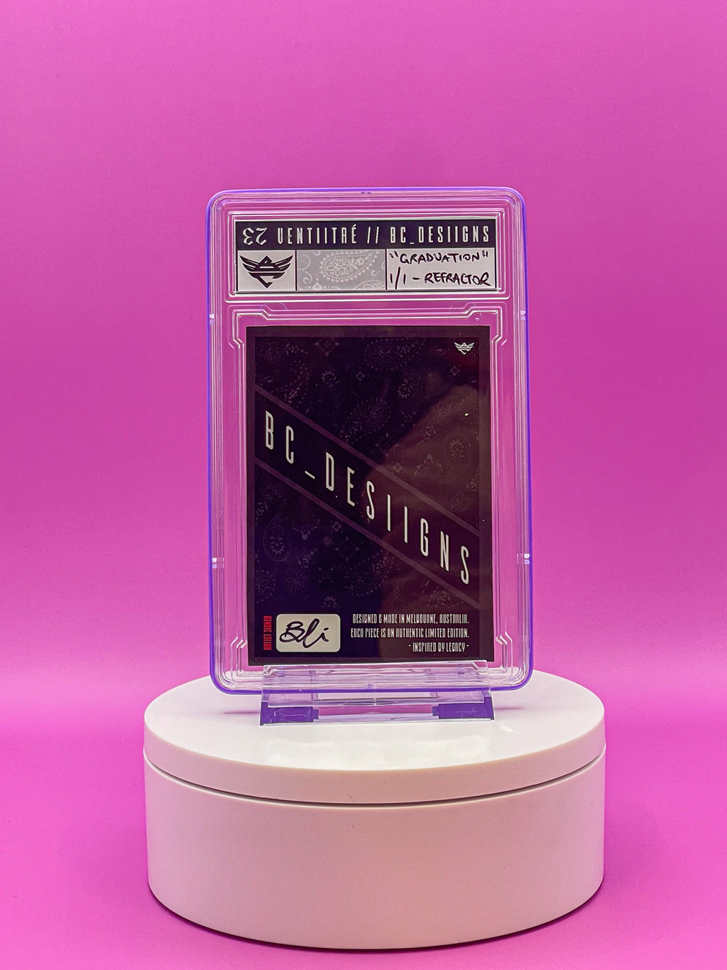 Card in a protective case on a white stand against a pink background