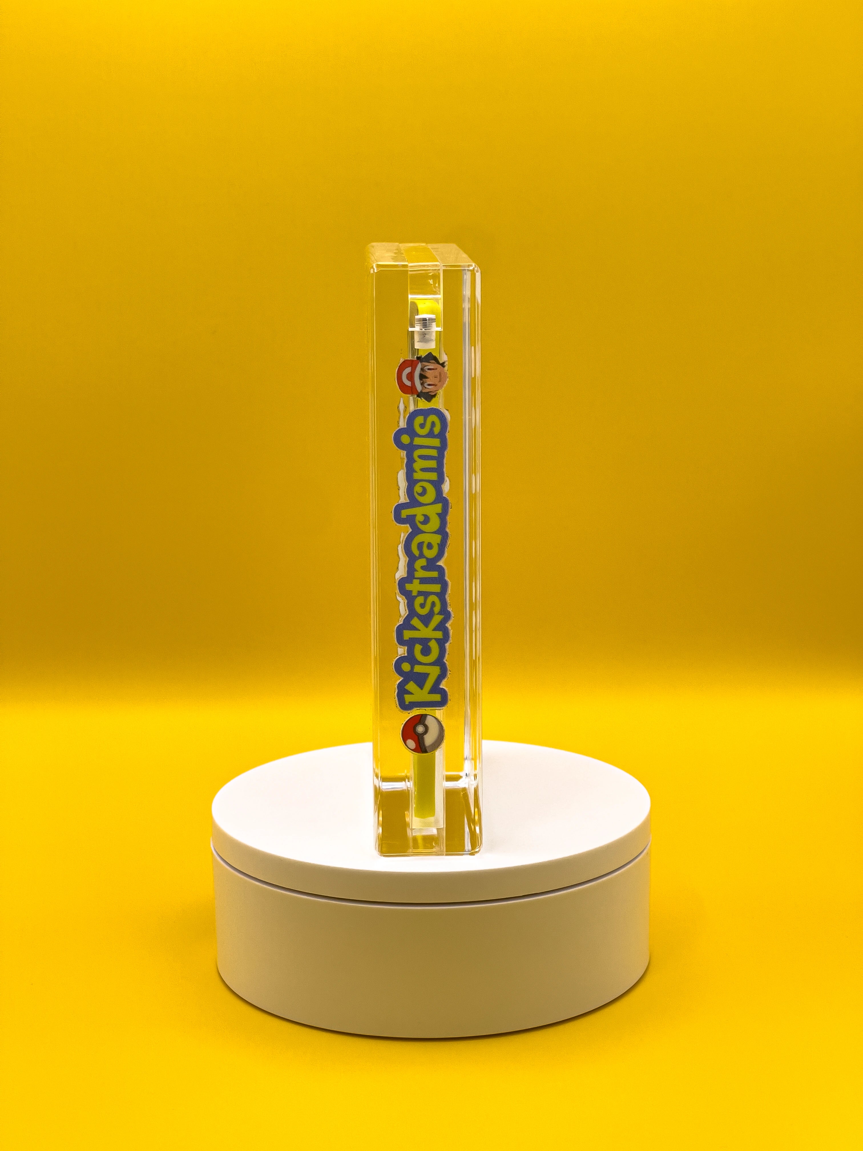 Side view of a collectible card in a protective case on a white platform with a yellow background